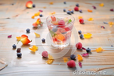 berry juice in clear cup, dewy berries scattered nearby Stock Photo