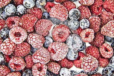 A Berry mix from frozen raspberries and blueberries. A Frozen Berries from freezer. A sweet background with frozen raspberries Stock Photo