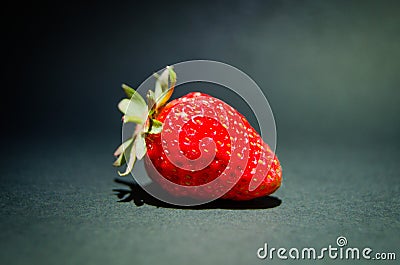 Berry of a red garden strawberry on a black background. Photo of fruit on a black background. Large red strawberry Stock Photo