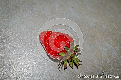 Berry of a red garden strawberry on a light background. Photo of fruit on a white background. Large red strawberry Stock Photo