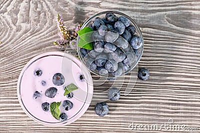 Berry smoothie or yogurt in glass and blueberries in bowl Stock Photo