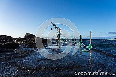 Berth with a crane on the north coast of the Atlantic Ocean, the village of El Pris. Stock Photo