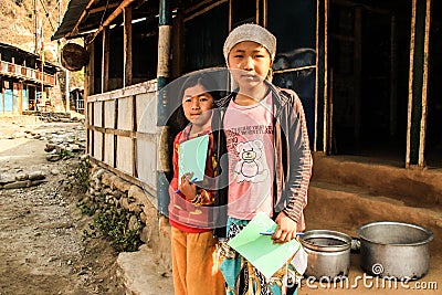 poor Nepalese girls in the Himalayan mountain region are holding school notebooks and pens from volunteer assistance to children Editorial Stock Photo