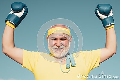 Best cardio workout. Happy Older man boxing - close up portrait. Active leisure. Senior man in gloves beats punching bag Stock Photo