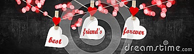 Best friends forever background banner panorama - White hearts hang on wooden clothes pegs hang on a string isolated on black Stock Photo