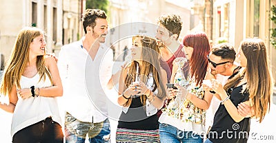 Best friends group having fun together walking on city street - Technology interaction concept in everyday lifestyle with Stock Photo
