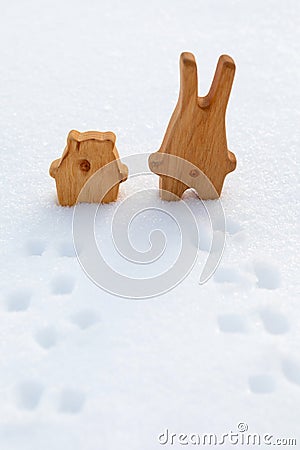 Best friends rabbit and bear are standing in snow and looking into expanse. Wooden toys to illustrate affection, love, emotional Stock Photo