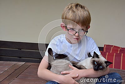 Best friends, schoolboy cuddles his little cat Stock Photo