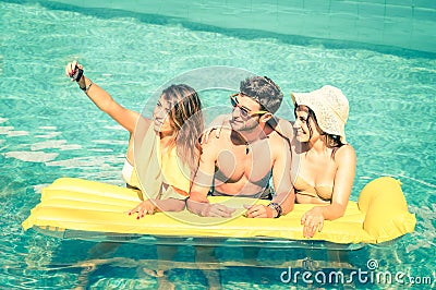 Best friends taking selfie at swimming pool with yellow airbed Stock Photo