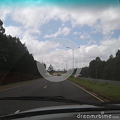 Best road perspective view, trees on sides, white clouds Stock Photo