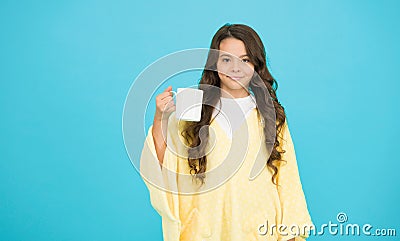 The best to drink in morning. happy girl with tea cup. good morning drink. small kid blue wall. little girl drink cocoa Stock Photo