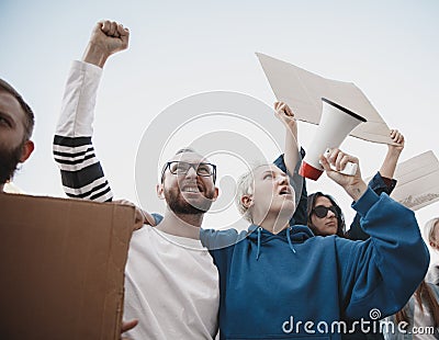 Group of activists giving slogans in a rally. Men and women marching together in a protest in the city. Stock Photo