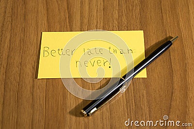 Better late than never handwrite on a yellow paper with a pen Stock Photo