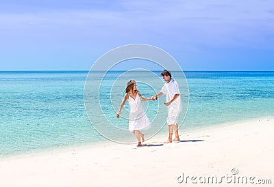 Beuatiful couple running on a tropical beach Stock Photo