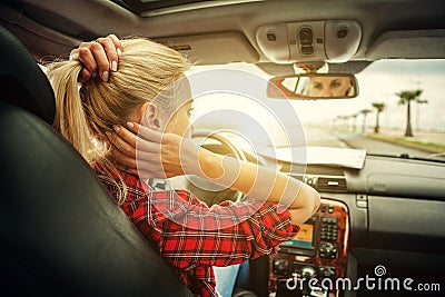 Beutiful blond girl comb her hair with a rearview mirror in car Stock Photo