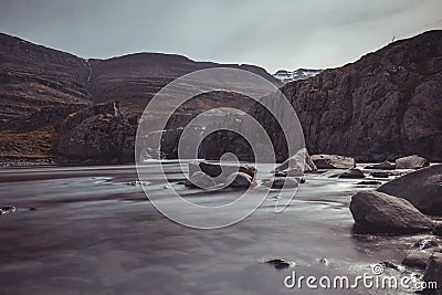 Beutiful water cascades above fossardalur waterfall in iceland with beautiful scenery around. Cloudy weather and long exposure Stock Photo