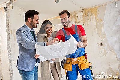 Beutiful young couple looking blueprints of their home with hand Stock Photo