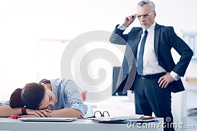Bewildered chief looking at his employee sleeping at work Stock Photo