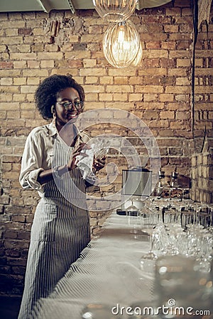 Bewitching beaming African-American cheerfully shining glasses at loft bar Stock Photo