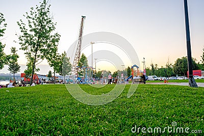 Playground and slides for children in Haskoy public park and Turkish people in their leisure time in summer with bright air Editorial Stock Photo