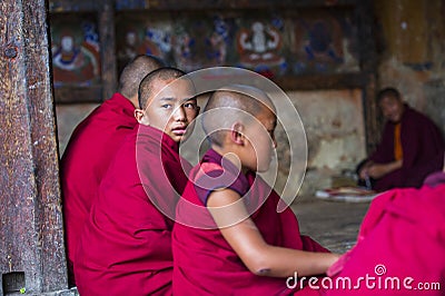A Bhutanese young novice monk turn his head to gaze the sky during study , Bhutan Editorial Stock Photo