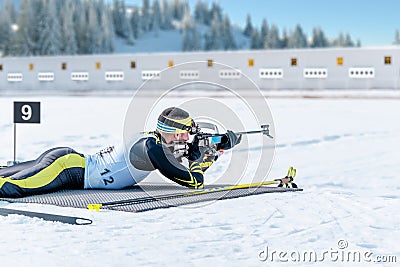 Biathlete lies and shoots a target at a 20 km race Stock Photo