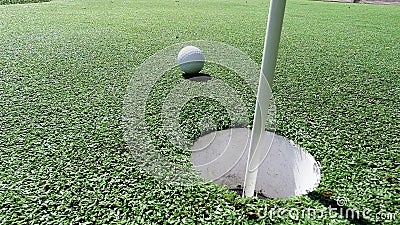 Biały piłki golfowej ciupnięcia flaga kij i spadać w dziurę na kładzenie zieleni Biały piłki golfowej ciupnięcia flaga kij i spadać w dziurę na kładzenie zieleni