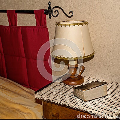 Bible on a bedside table under a lamp in a rustic style Stock Photo
