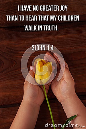 Bible charity quotes for believers. Inspirational Christian verse Child hand hold yellow tulip flower. Love care support Stock Photo