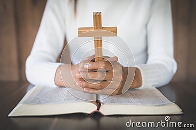 Bible and crucifix. A young woman asks blessings from God with the power and power of holiness, which brings luck and shows Stock Photo