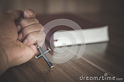 Bible and crucifix. A young woman asks blessings from God with the power and power of holiness, which brings luck and shows Stock Photo
