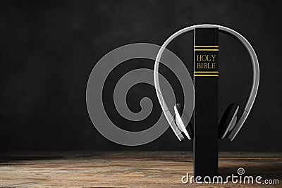 Bible and headphones on table, space for text. Religious audiobook Stock Photo
