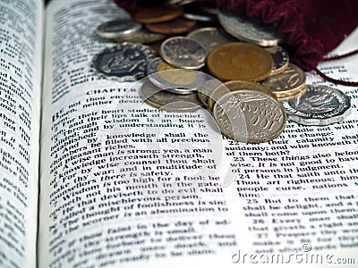 Bible opened to the Book of Proverbs with Coins Stock Photo