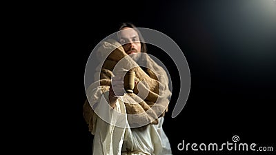 Biblical prophet in robe giving wooden mug with water, help and hope, religion Stock Photo