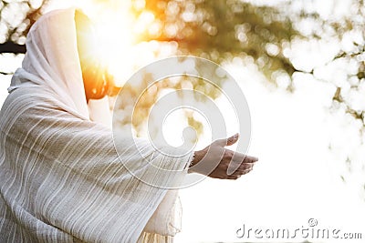 Biblical scene - of Jesus Christ landing a hand for help with the sun shining near his face Stock Photo