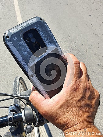 Bicker holding his smart phone with strong metal case Stock Photo