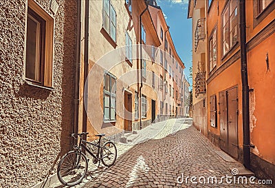 Bicycle abandoned on narrow colorful street with old houses of Gamla Stan Old Town in Sockholm, Sweden. Stock Photo