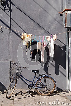 Bicycle airing clothes wall Stock Photo