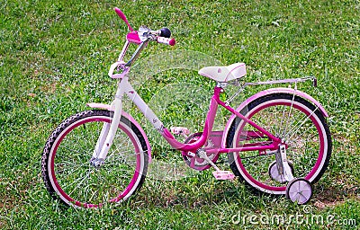 The bicycle for the girl on a green lawn. Stock Photo
