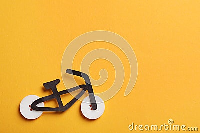 Bicycle made with buttons and black cutout on orange background, flat lay. Space for text Stock Photo