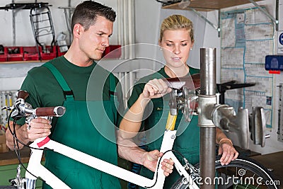 Bicycle mechanic and apprentice repairing a bike Stock Photo