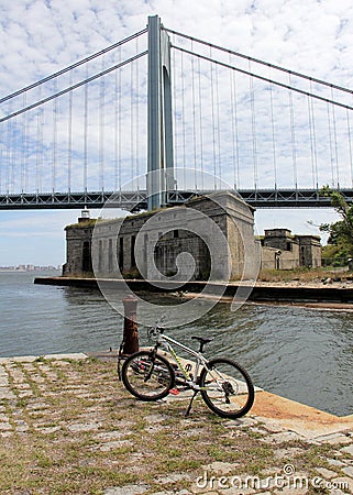 Bicycle on an old stone pier, Battery Weed and Verrazzano Bridge in the background, Staten Island, NY, USA Editorial Stock Photo