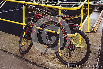 Bicycle padlocked to a yellow rail in Fraserburgh Harbour,Aberdeenshire, Scotland, UK. Stock Photo