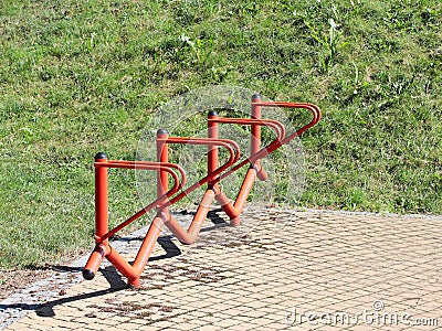 Bicycle park. Metal orange handrails for parking bicycles. A device to make life easier for cyclists. Facilities for the city`s ec Stock Photo