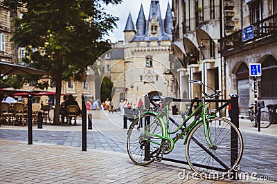 Bicycle parked against railing in Bordeaux with Port Cailhau in Editorial Stock Photo