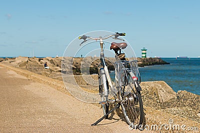 Bicycle parked on Scheveningen harbour entance wall Stock Photo