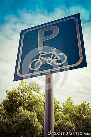 Bicycle parking sign on blue sky and tree with filter Stock Photo