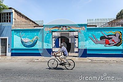 A bicycle passing in front of a graffiti wall Editorial Stock Photo