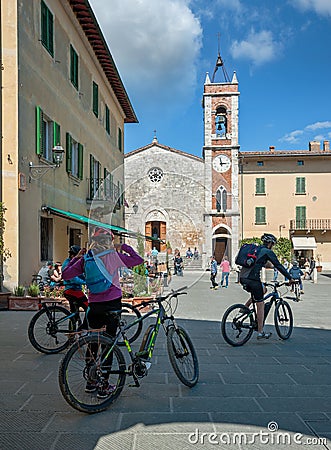 Bicycle riders in front of the church of San Francesco, San Quir Editorial Stock Photo