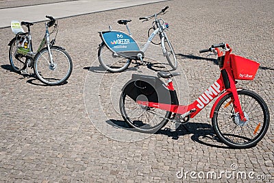 Bicycle sharing bikes for rent from DEEZER, LIDL and JUMP by UBER on street in Berlin Editorial Stock Photo